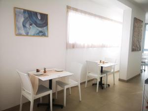a dining room with two tables and white chairs at Hotel Mare Blu in Torre dell'Orso