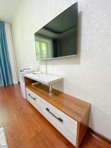 un soggiorno con una TV a parete di Апартаменты аэропорт a Almaty