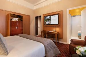 a hotel room with a bed and a desk at Hôtel Barrière Le Westminster in Le Touquet-Paris-Plage