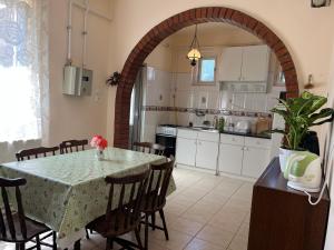 uma cozinha com mesa e cadeiras e uma cozinha com armários brancos em Rose Garden em Siófok