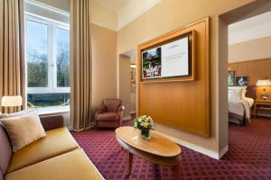 a hotel room with a couch and a table and a bed at Hôtel Barrière Le Westminster in Le Touquet-Paris-Plage
