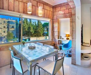 comedor con mesa y sillas y ventana grande en Luxury apartment in the heart of the German colony, en Jerusalén