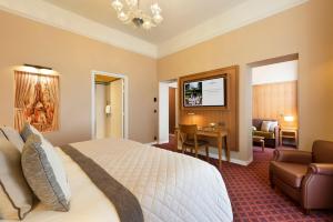 a hotel room with a bed and a living room at Hôtel Barrière Le Westminster in Le Touquet-Paris-Plage