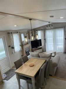 a dining room with a wooden table and chairs at Mersea Villa in West Mersea