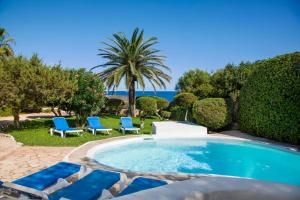 basen z niebieskimi krzesłami i palmą w obiekcie Villa Mar Gran w mieście Cacla D'or