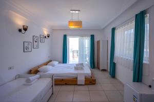 a bedroom with two beds and a large window at Sole'n Blu in Kaş
