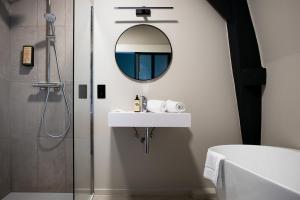 W łazience znajduje się umywalka i lustro. w obiekcie Hôtel de la Poste w mieście Ellezelles
