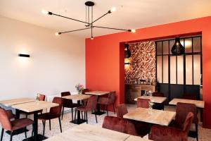 um restaurante com mesas e cadeiras e paredes vermelhas em Hôtel de la Poste em Ellezelles