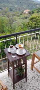 een tafel met borden eten en drinken op een balkon bij Vacation House Dionysia in Aigio
