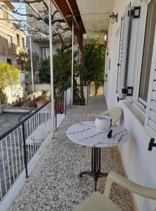 patio ze stołem i krzesłami na balkonie w obiekcie Vacation House Dionysia w mieście Ejo