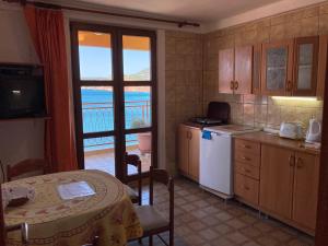 a kitchen with a table and a view of the ocean at Monterama Apartments in Sutomore