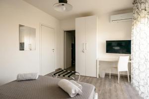 a white bedroom with a bed and a desk at b&b airport bari-palese luxury 1 in Bari