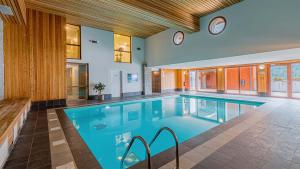 a large swimming pool with a clock on the wall at Madame Vacances La Cascade in Vaujany