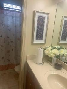 La salle de bains est pourvue d'un lavabo, de toilettes et d'un miroir. dans l'établissement Relaxation Zone, à West Palm Beach