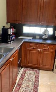 a kitchen with wooden cabinets and a rug on the floor at Relaxation Zone in West Palm Beach