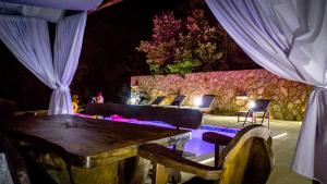 Una mesa y algunas sillas y una pared de piedra. en Villa Mira Makarska - Imotski, en Imotski