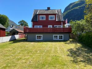 a large red house with a large yard at Aurland Guesthouse in Aurland