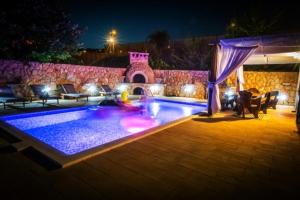 a swimming pool in a backyard at night at Villa Mira Makarska - Imotski in Imotski