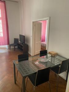 una sala da pranzo con tavolo in vetro e sedie di Impeccable 3-Bed Apartment close to the River a Praga