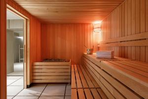 a sauna with wood paneling and a glass door at Hôtel Barrière Le Westminster in Le Touquet-Paris-Plage