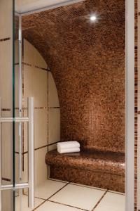 a bathroom with a brick wall and a bench at Hôtel Barrière Le Westminster in Le Touquet-Paris-Plage