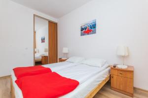 um quarto com uma cama grande e um cobertor vermelho em Relaks Kąty Rybackie em Kąty Rybackie