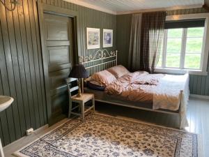 a bedroom with a bed and a window at Steinsvoll Gård in Vang I Valdres