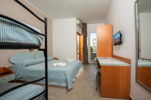 una camera con 2 letti a castello, una scrivania e un letto di HOTEL GIARDINO a Cesenatico