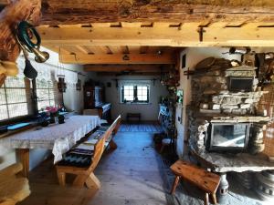 a dining room with a table and a stone fireplace at Siedlisko na Groniku in Kokuszka