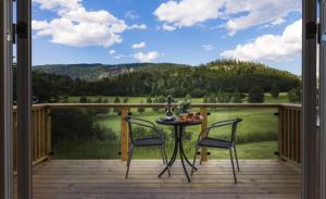 un balcón con 2 sillas y una mesa con fruta. en Stokke Gård Burglamping en Stjoerdal