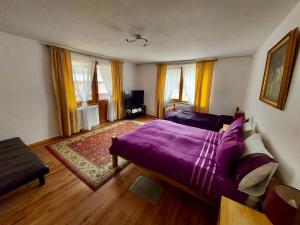 1 dormitorio con cama morada y sofá en Cabana Sweetlife en Rimetea