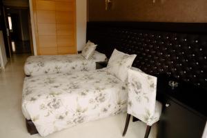 a bedroom with a bed and a chair in it at Hotel La Luna in Beni Mellal