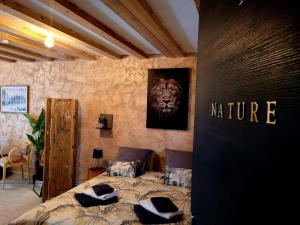 a bedroom with a bed with aulture sign on the wall at Ambition Bien Etre Adulte Only in Marseillan +4 photos