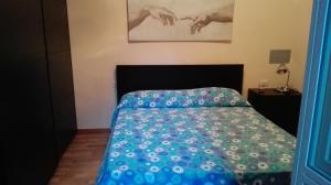 1 dormitorio con 1 cama con edredón azul en Scario Sunny Apartment in centro, en Scario
