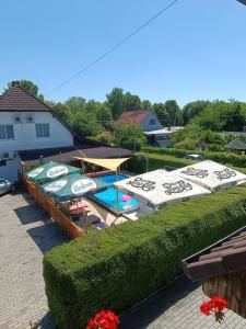 a patio with umbrellas and a swimming pool at Janika Pension in Vonyarcvashegy