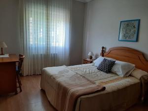 um quarto com uma cama grande e uma janela em Lhamo Mandala House em Pontevedra