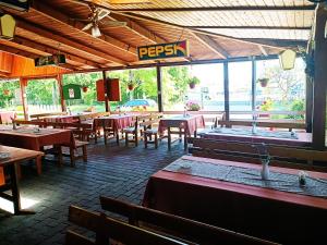 un restaurant avec des tables et des chaises et un panneau indiquant pepsi dans l'établissement Janika Pension, à Vonyarcvashegy