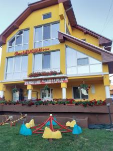 un edificio amarillo con un parque infantil delante de él en Casa Leucian en Deva