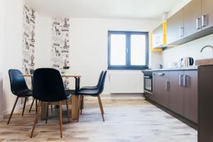una cucina con tavolo e sedie in una stanza di The Home Sweet Home a Gheorgheni