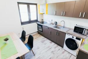 a kitchen with a sink and a table with chairs at The Home Sweet Home in Gheorgheni +13 photos