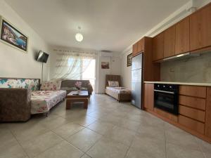 ein Wohnzimmer mit einem Sofa und einer Küche in der Unterkunft Alma Room in Sarandë