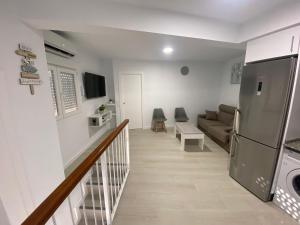 sala de estar con sofá y nevera en apartamento isabel, en Ardales