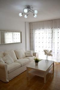 a living room with a white couch and a coffee table at Apartamento IGUAZU in Playa del Ingles