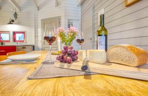 a table with a bottle of wine and bread and wine glasses at traumHaff - Sea Hideaway Ostsee Region - privates NORDICSPA, Kamin, Kunst, Hund 300m zum Strand in Rieth