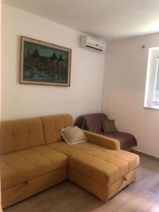 a living room with a brown couch and a chair at Apartments Zamicka in Brela