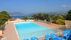 ein großer Pool mit blauen Stühlen und Wasser in der Unterkunft Studio avec terasse vue mer in Porticcio