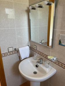 a bathroom with a white sink and a mirror at Hotel Restaurante La Cañada in Fuencaliente de Lucio