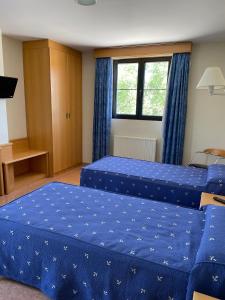 a bedroom with two beds and a window at Hotel Restaurante La Cañada in Fuencaliente de Lucio +2 photos