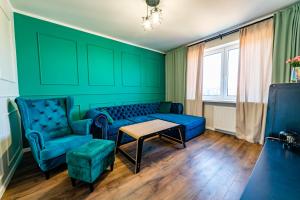 a living room with blue furniture and green walls at Apartament z Widokiem in Mikołajki