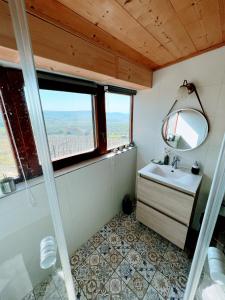 uma casa de banho com um lavatório, um espelho e uma janela em Bakos Pincészet Csobánc Bástya és Borterasz em Gyulakeszi